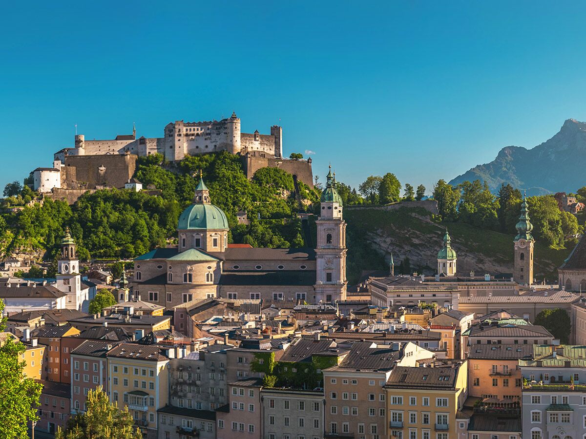 Panoramablick auf die historische Altstadt von Salzburg mit der Festung Hohensalzburg, dem Dom und den Alpen.