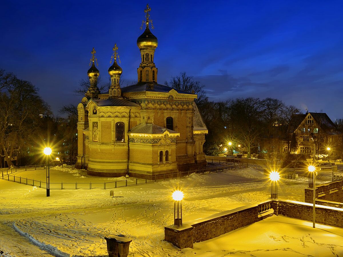 Die Russische Orthodoxe Kapelle in Darmstadt, im Winter nachts mit Schnee und leuchtenden Laternen, goldene Kuppeln.