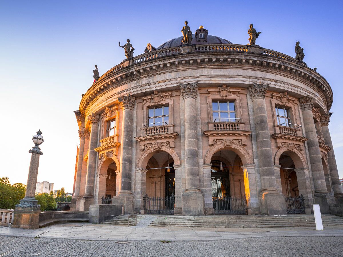 Das imposante Bode-Museum auf der Museumsinsel in Berlin, beleuchtet von der goldenen Stunde am Morgen oder Abend.