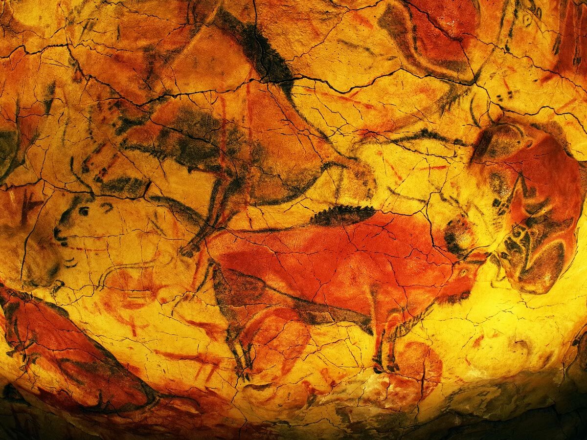 Detail der berühmten prähistorischen Höhlenmalerei von Altamira, die lebendige Bisons und andere Tiere in Rot und Schwarz auf gelber Felswand zeigt.