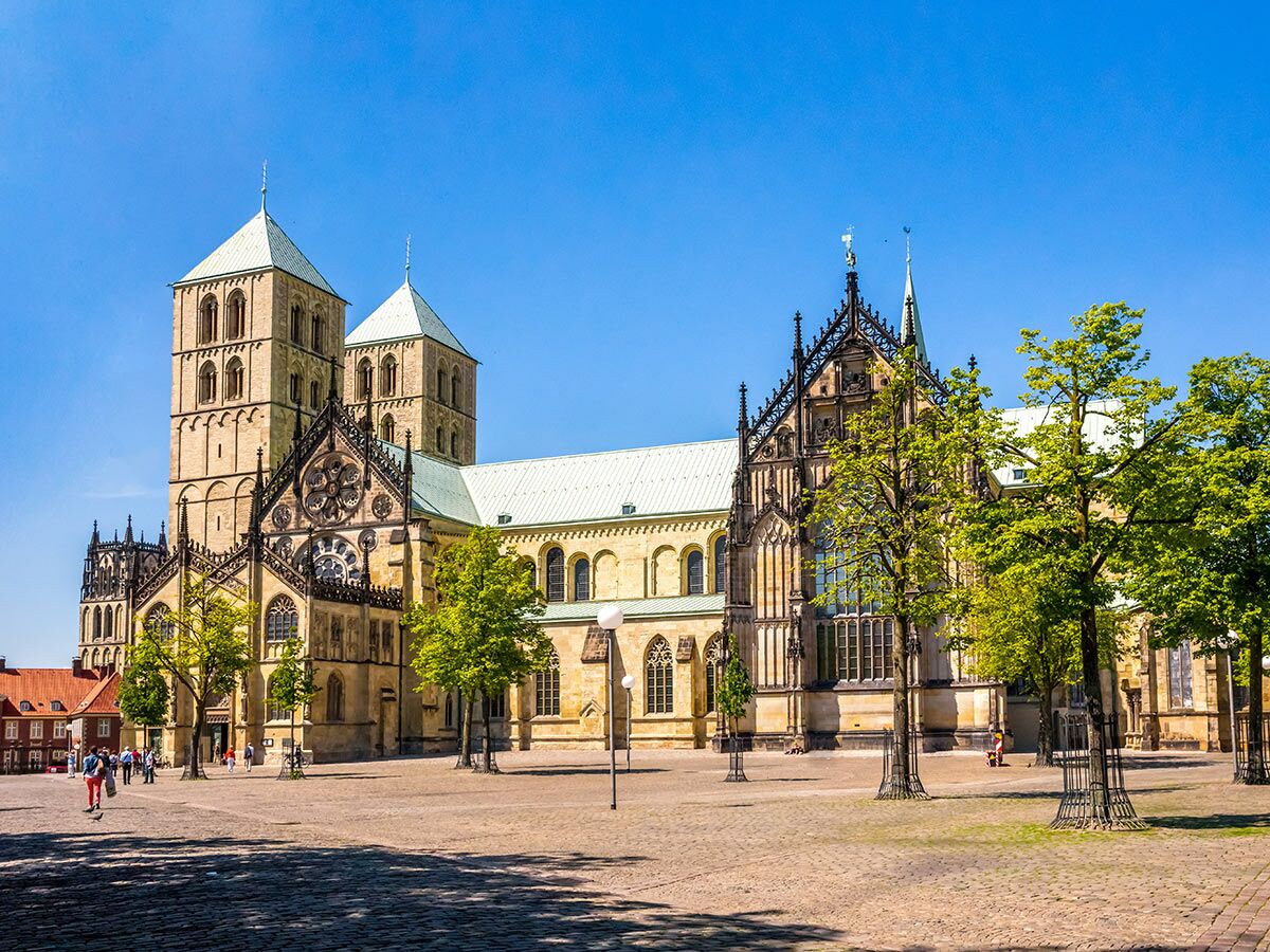 Panoramablick auf den St.-Paulus-Dom in Münster, Deutschland, eine beeindruckende historische Kathedrale unter blauem Himmel.