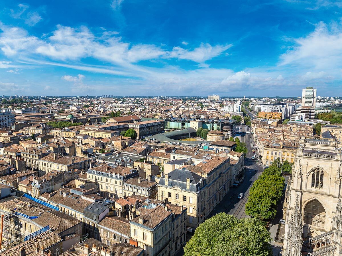 Bordeaux Stadtansicht aus der Vogelperspektive mit historischen Gebäuden, roten Dächern, belebter Straße und der Saint-André Kathedrale.