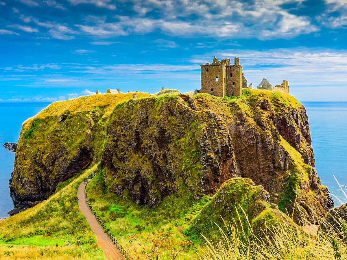 Dunnottar Castle, eine historische Festung, thront majestätisch auf einer steilen Klippe an der schottischen Küste, umgeben vom blauen Meer.