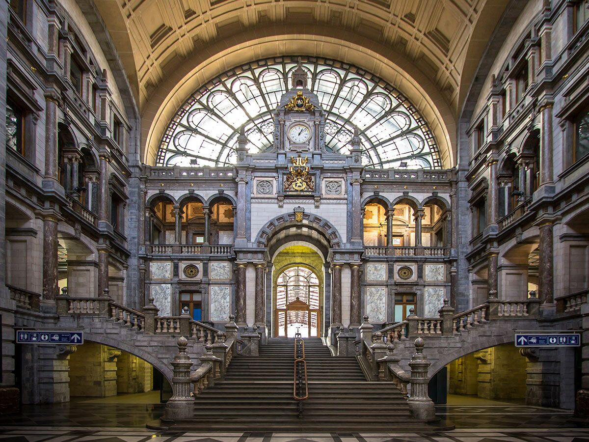 Antwerpen Hauptbahnhof imposante Eingangshalle mit großer Fensterrose, Uhr, Marmor und majestätischer Freitreppe.