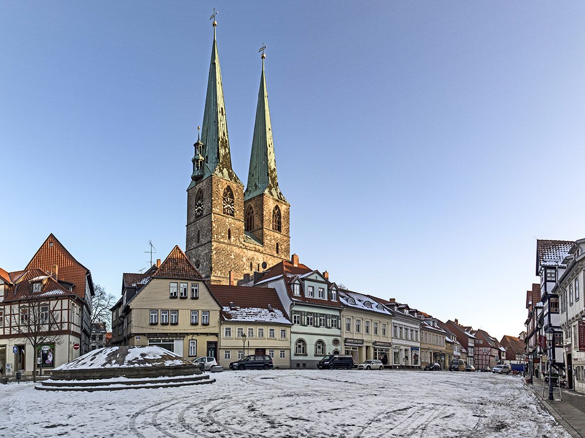 Winterlicher Marktplatz in Salzwedel mit der imposanten Marienkirche, historischen Fachwerkhäusern und verschneitem Brunnen.