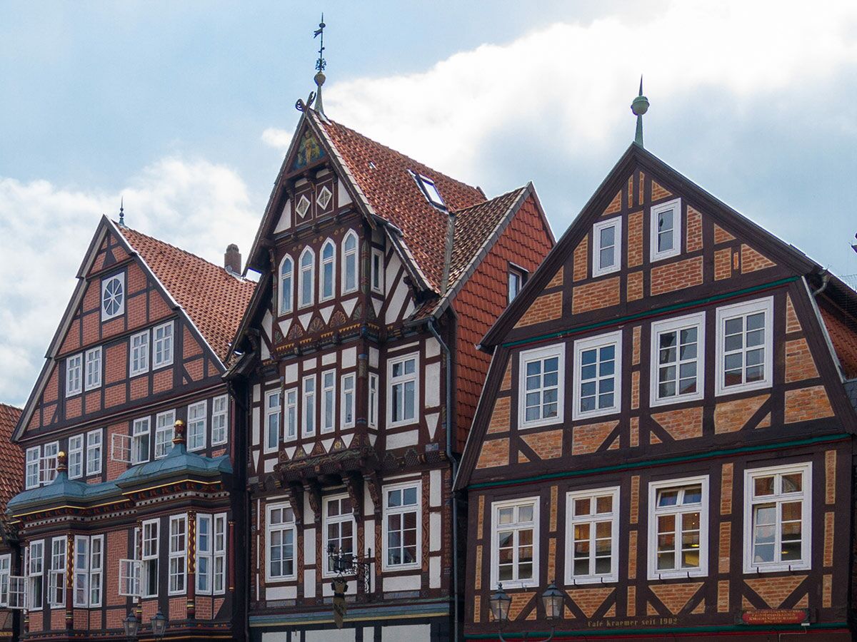 Detailansicht mehrerer historischer Fachwerkhäuser mit roten Ziegeldächern, weißen Fenstern und Holzbalken in einer deutschen Stadt.