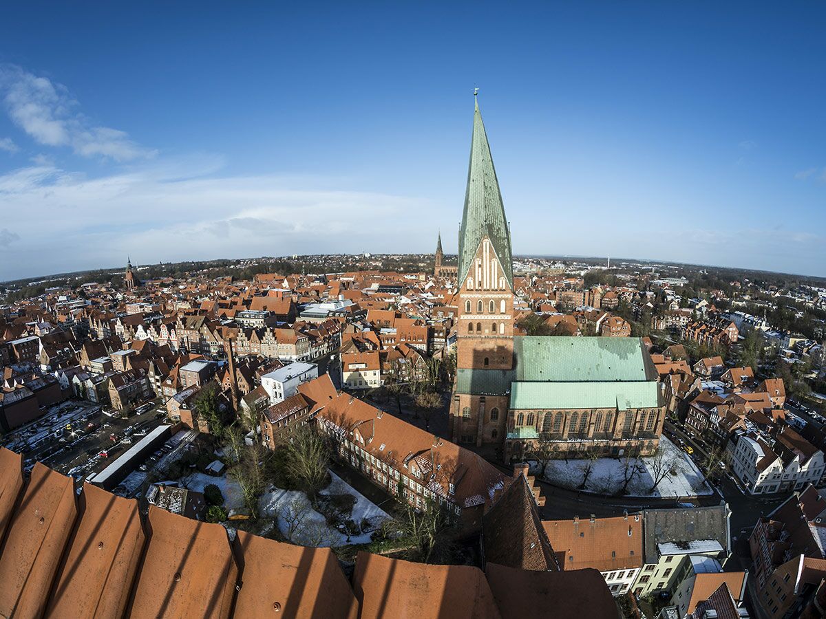 Luftbild Lüneburgs: St. Michaelis Kirche, rote Dächer, blauer Himmel, winterliche Stadtansicht.