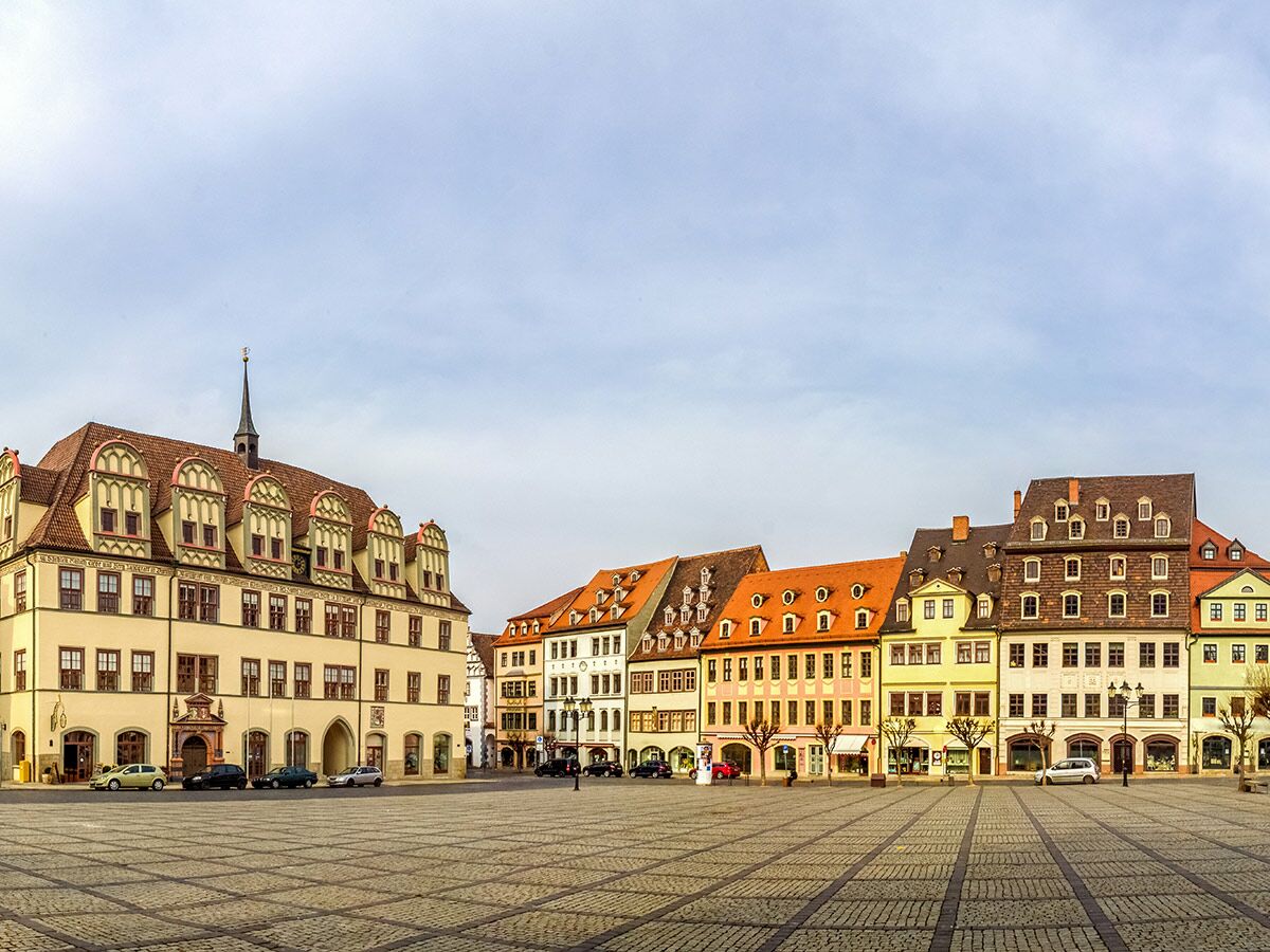 Panoramablick auf den leeren historischen Marktplatz Mittweida mit Kopfsteinpflaster, umgeben von bunten Altstadtgebäuden und dem Rathaus.