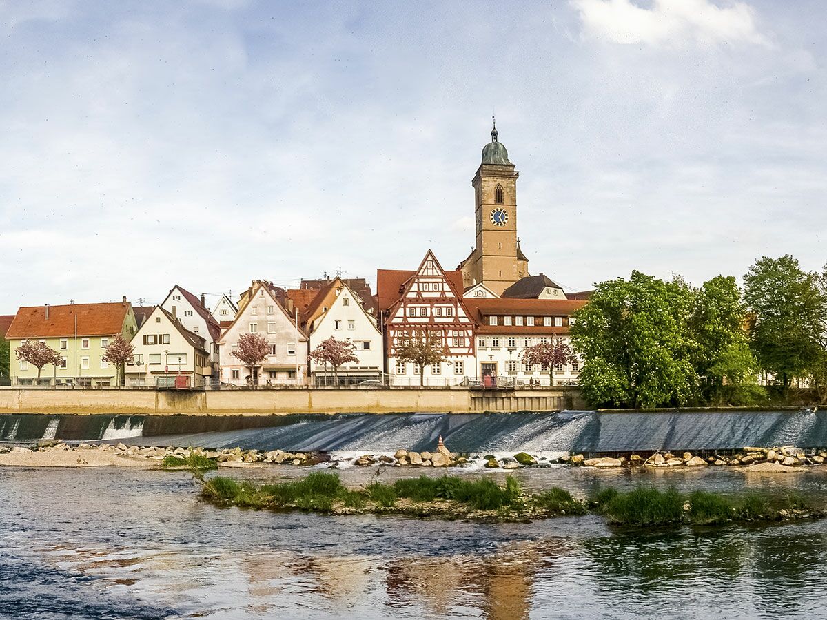 Panoramablick auf Schwäbisch Hall mit Fachwerkhäusern am Kocher, St. Michael Kirche und Wehr im Frühling.