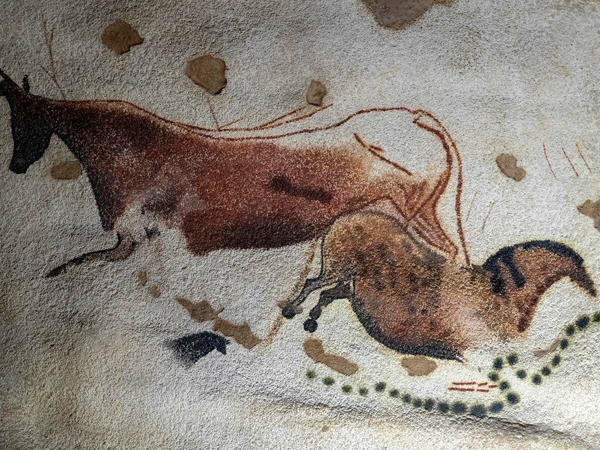 Detaillierte prähistorische Höhlenmalerei mit Bison, Pferd oder Auerochse, roten Linien und Punkten an einer Höhlenwand.