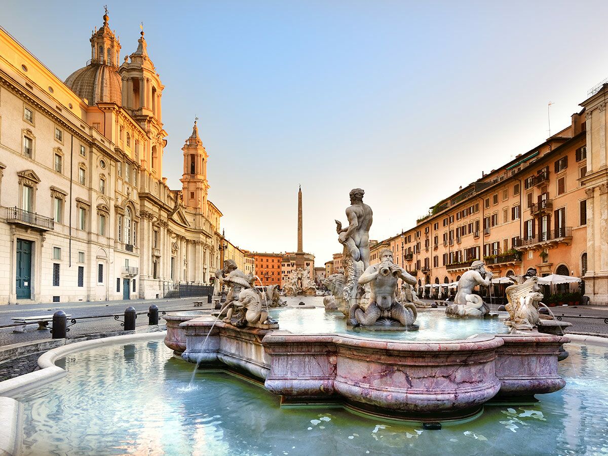 Historischer Piazza Navona in Rom mit Barockbrunnen, Statuen und Sant'Agnese in Agone Kirche im sanften Morgenlicht.
