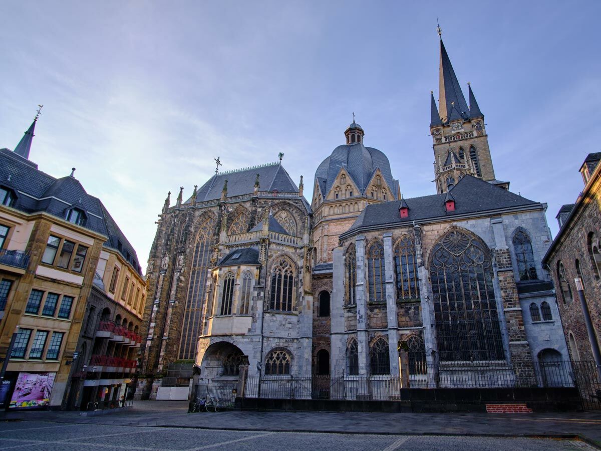 Der beeindruckende Aachener Dom mit seiner gotischen Architektur, hohen Türmen und Dome unter blauem Himmel in der Altstadt.