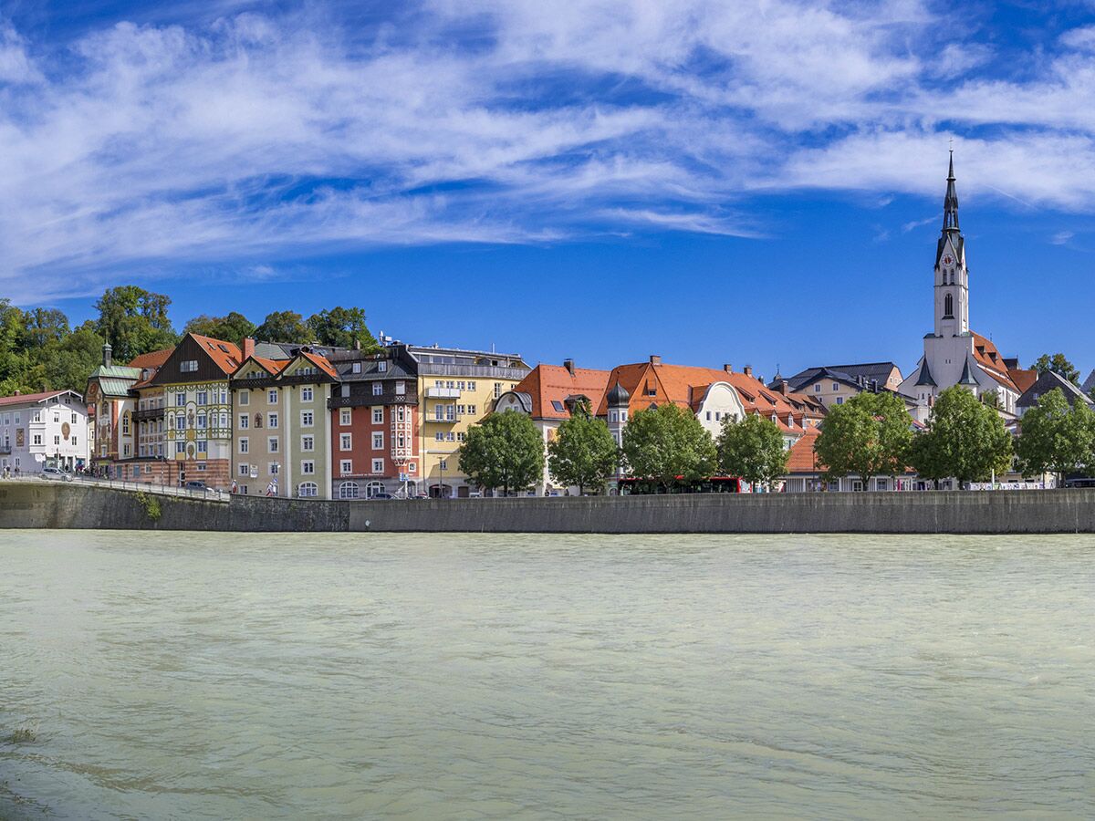 Panoramablick auf Füssen, die Altstadt am Lech Flussufer, mit farbenfrohen Gebäuden und der markanten Heilig-Geist-Spitalkirche.