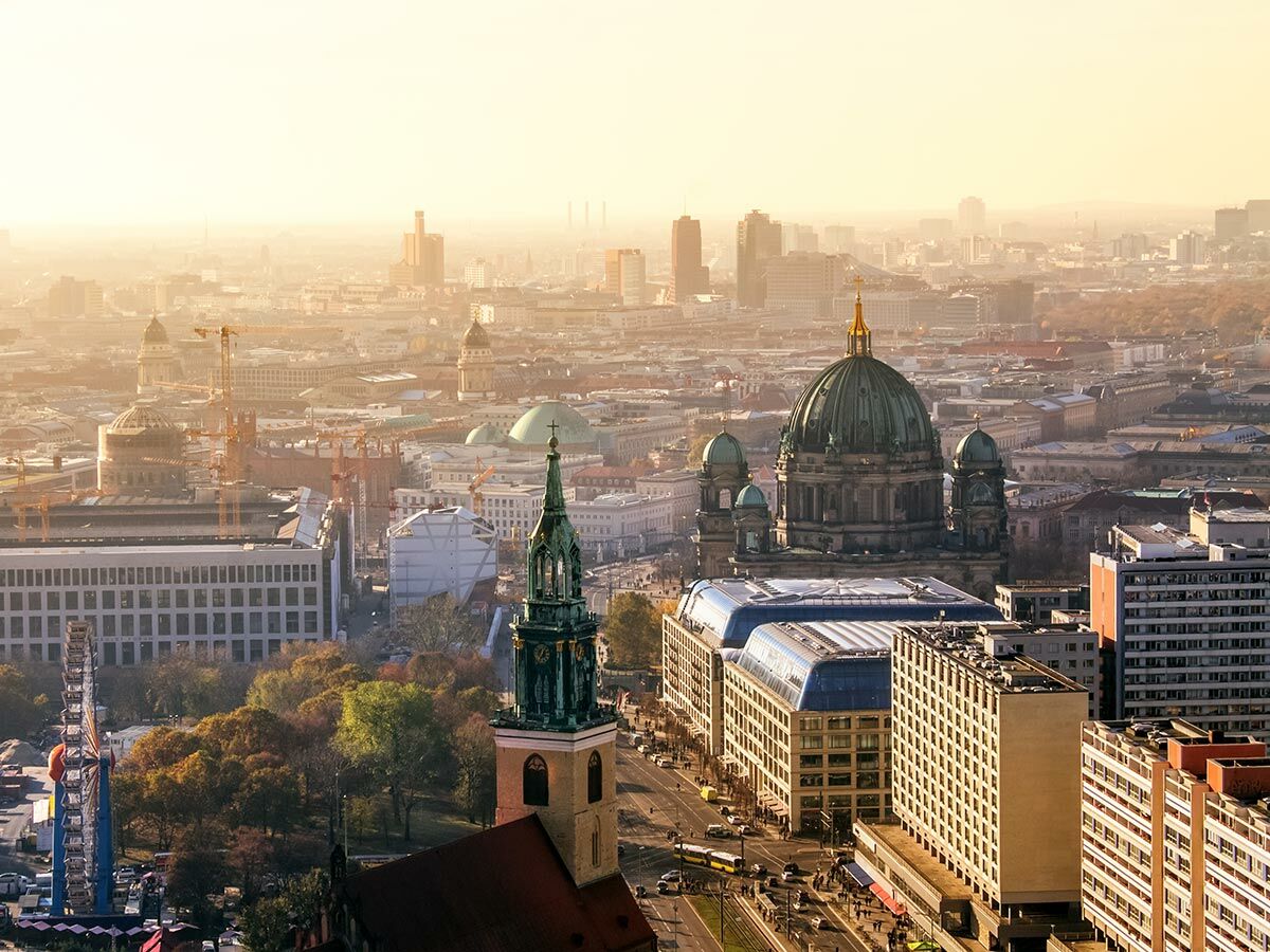 Luftbild von Berlin im Sonnenlicht mit Berliner Dom, St. Marienkirche, Hochhäusern und Verkehr während der goldenen Stunde.