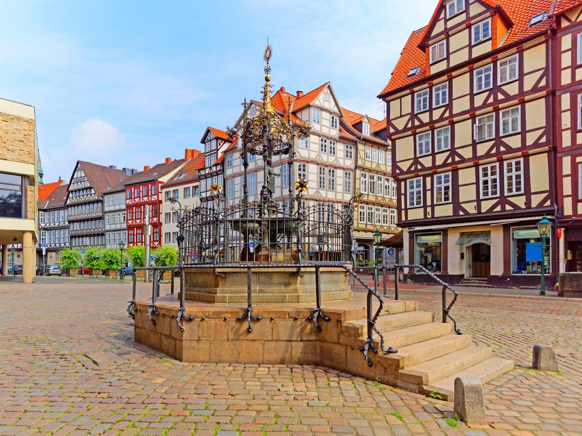 Historischer Marktplatz mit einem reich verzierten Brunnen, umgeben von traditionellen Fachwerkhäusern in einer deutschen Altstadt.