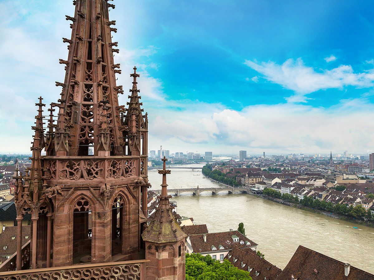 Luftaufnahme des Basler Münsterturms mit gotischen Steinmetzarbeiten, Blick über den Rhein und das Stadtpanorama.