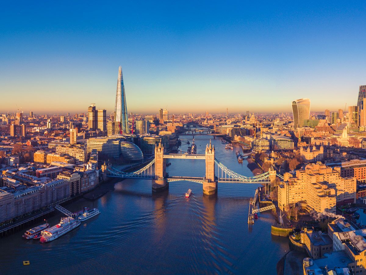 Panoramablick auf die Londoner Skyline mit Tower Bridge, The Shard und Themse im warmen Licht des Sonnenuntergangs.