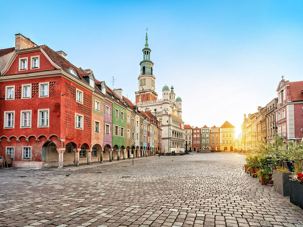 Sonniger Altstadt Marktplatz in Poznan, Polen, mit bunten historischen Bürgerhäusern, Kopfsteinpflaster und dem Rathaus.