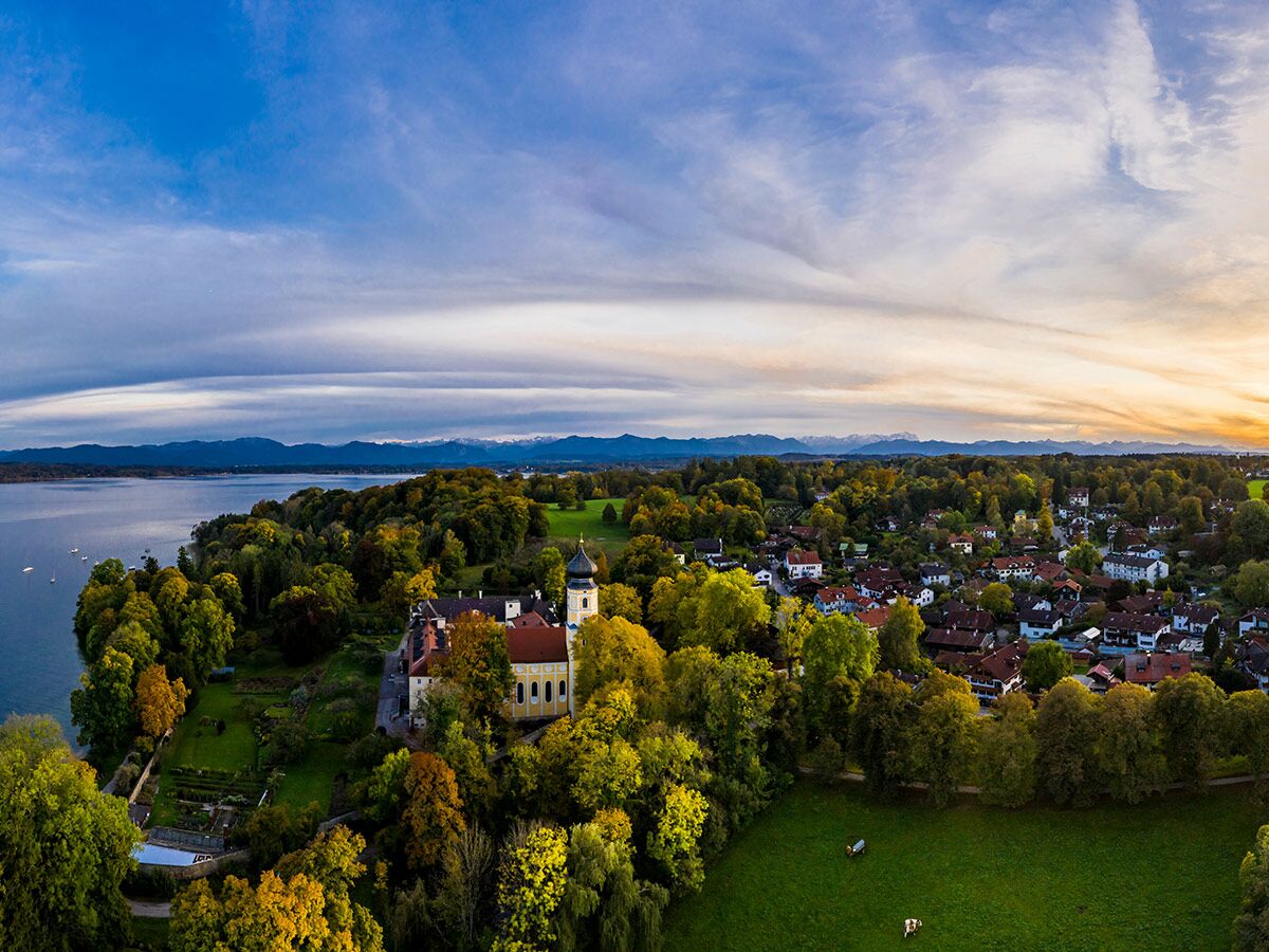 Luftbild von Kloster Andechs am Starnberger See mit Alpenpanorama bei Sonnenuntergang und bunten Herbstbäumen.