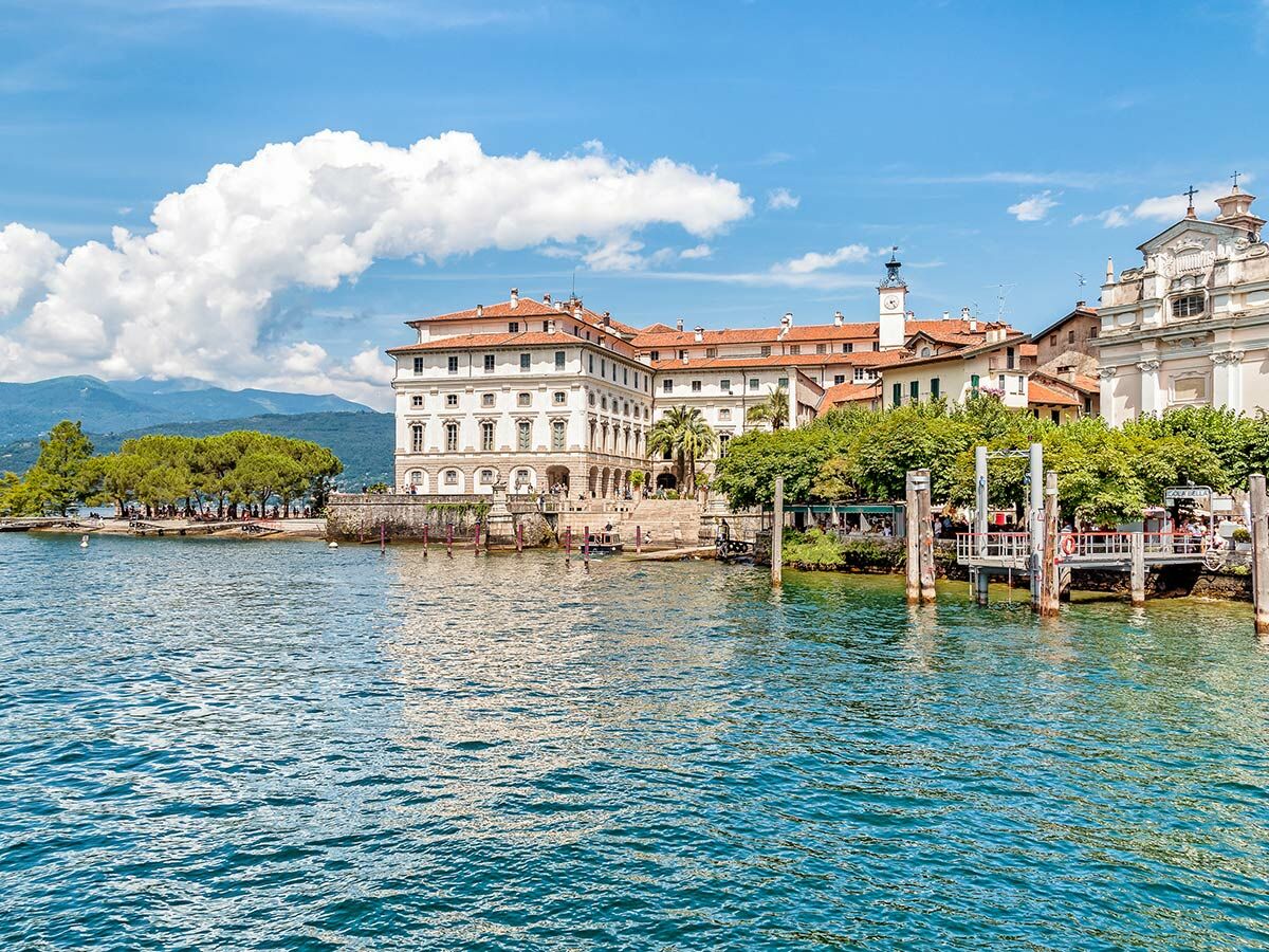 Panoramablick auf die prächtige Isola Bella im Lago Maggiore, mit historischen Gebäuden, Kirche, blauem See und Bergen.