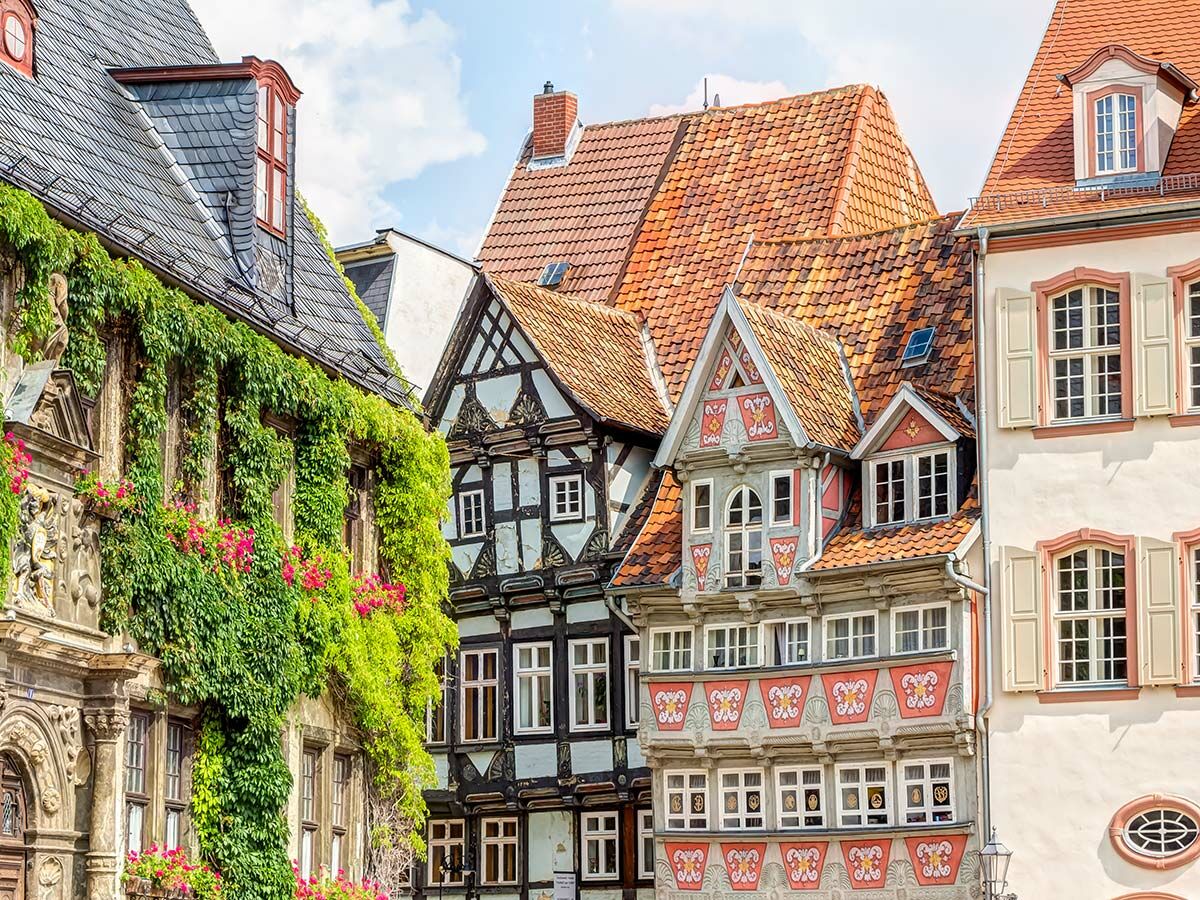 Malerische historische Gebäude in einer deutschen Altstadt, darunter ein von Efeu bewachsenes Haus und ein Fachwerkhaus.