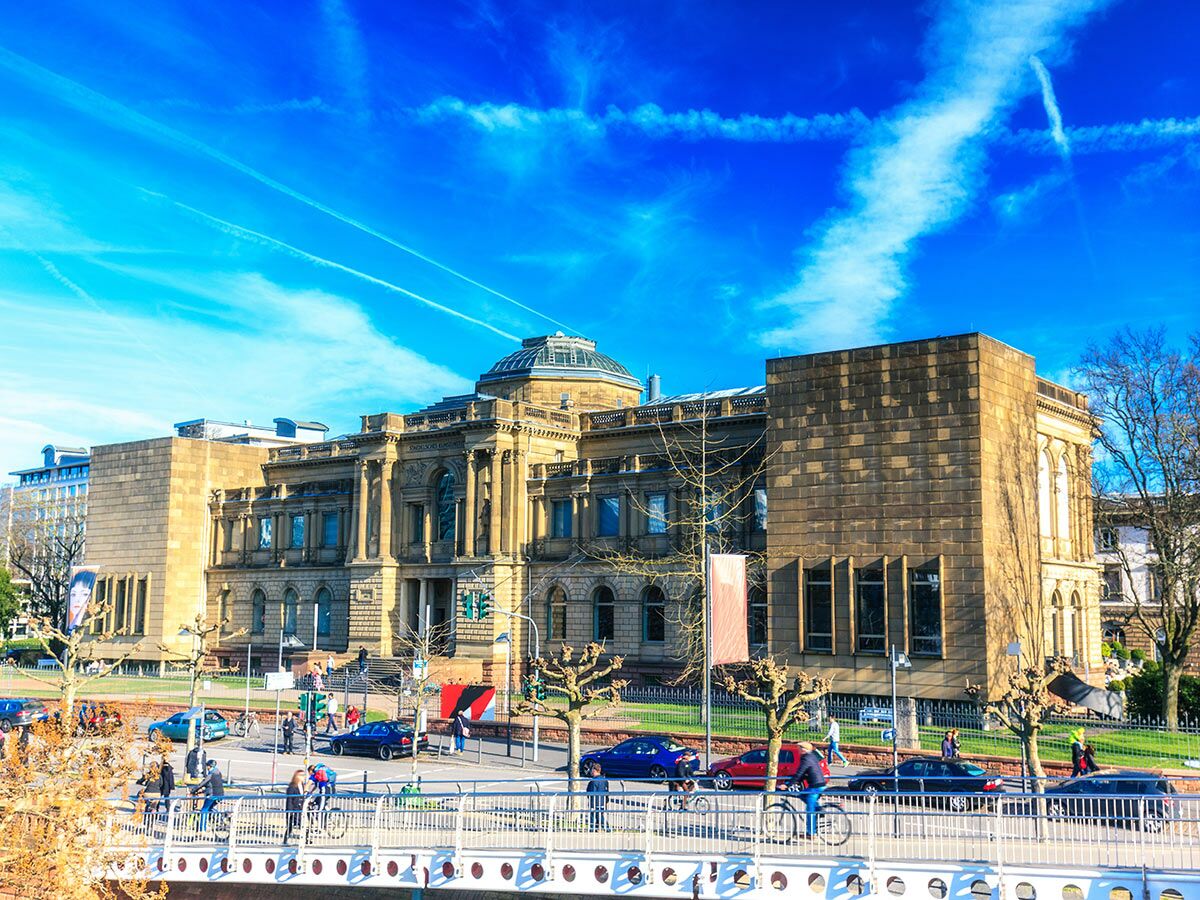 Historisches Städel Museum Frankfurt am Main mit Kuppel und modernem Anbau unter blauem Himmel mit Brücke, Menschen und Autos.