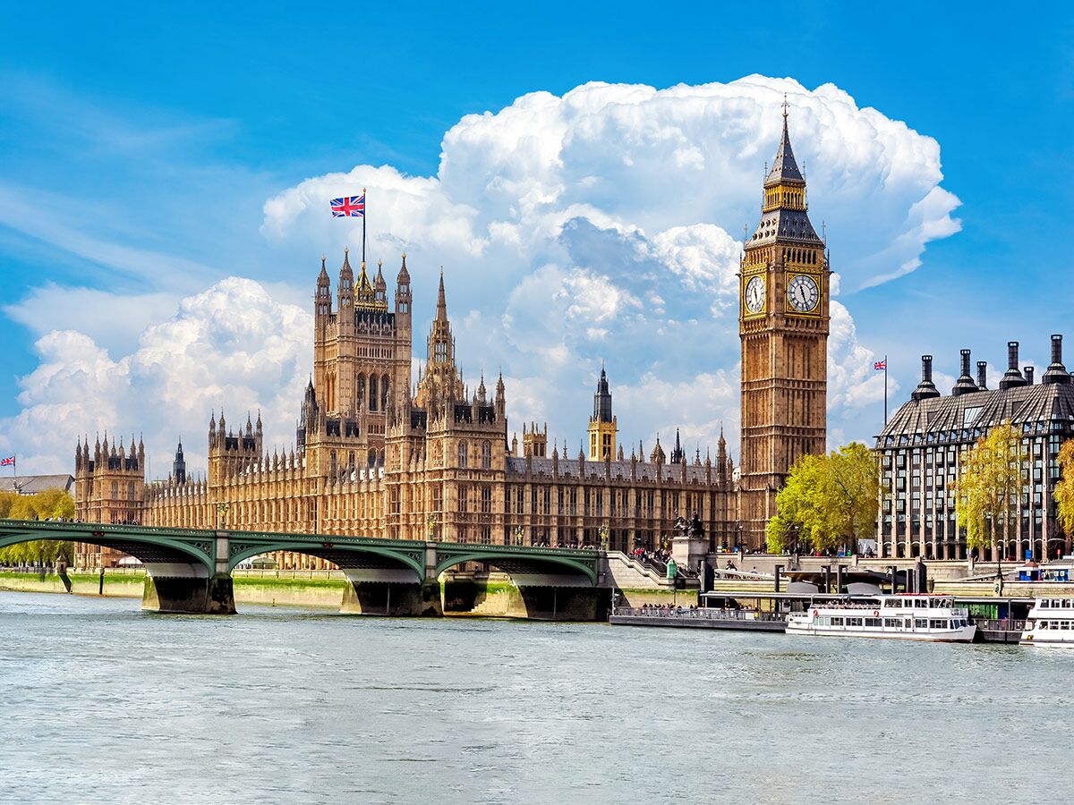 Blick auf Big Ben, Houses of Parliament und Westminster Bridge über die Themse in London an einem sonnigen Tag.