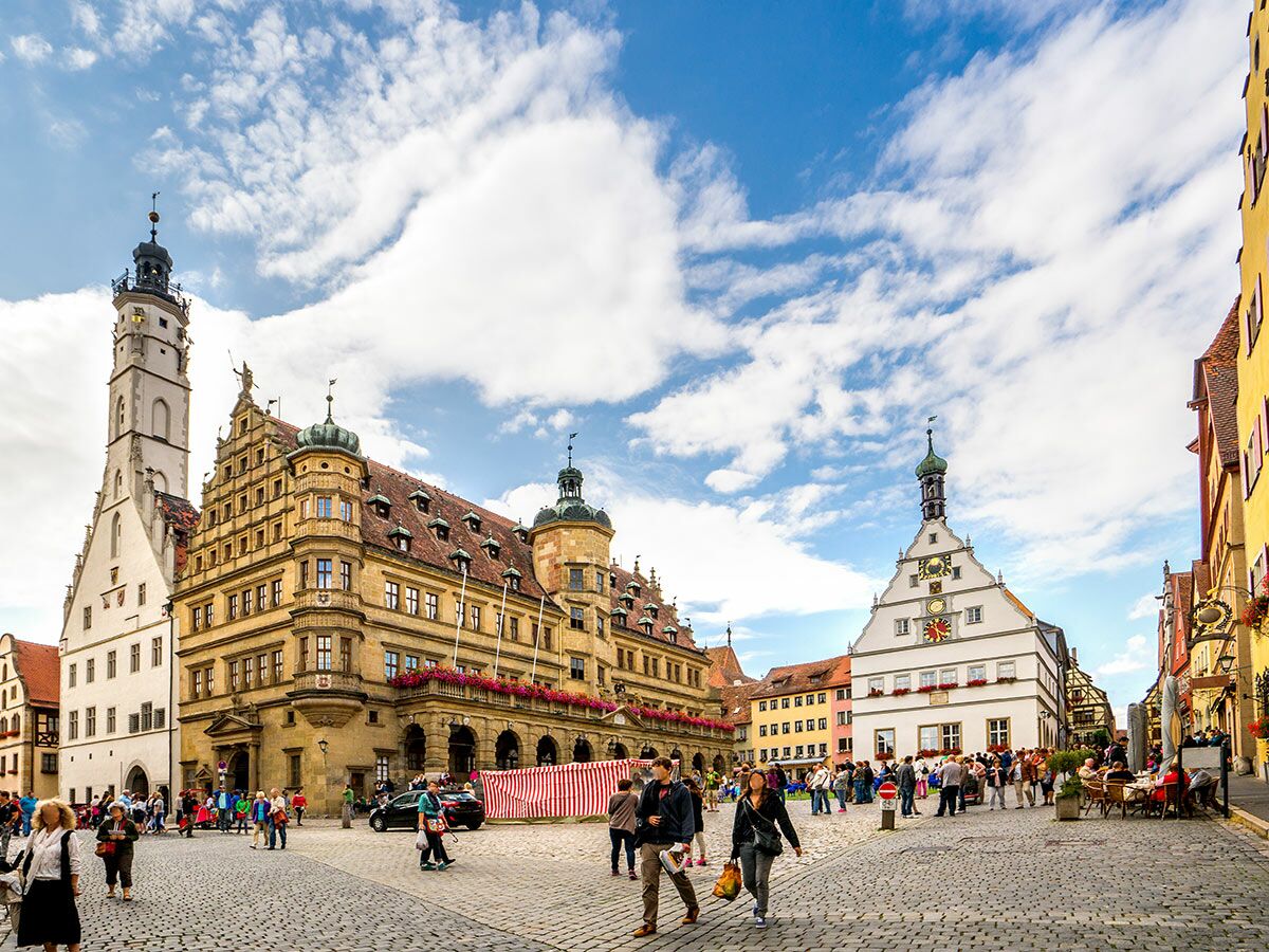 Blick auf den historischen Marktplatz in Rothenburg ob der Tauber mit Rathaus, Rathausturm und vielen Menschen.