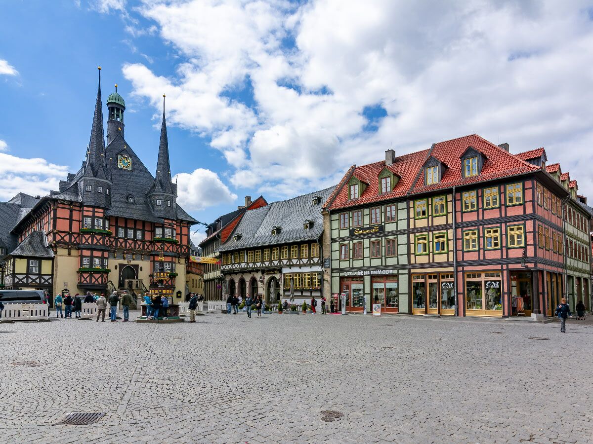 Historischer Marktplatz Wernigerode mit dem imposanten Rathaus und farbenfrohen Fachwerkhäusern unter bewölktem Himmel.