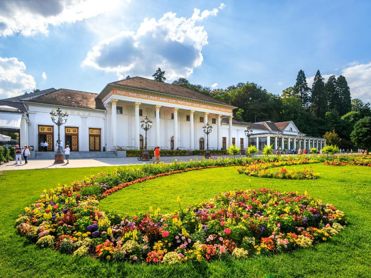 Prunkvolles Kurhaus in Baden-Baden mit klassischer Architektur und blühenden Blumenbeeten im Sommer.