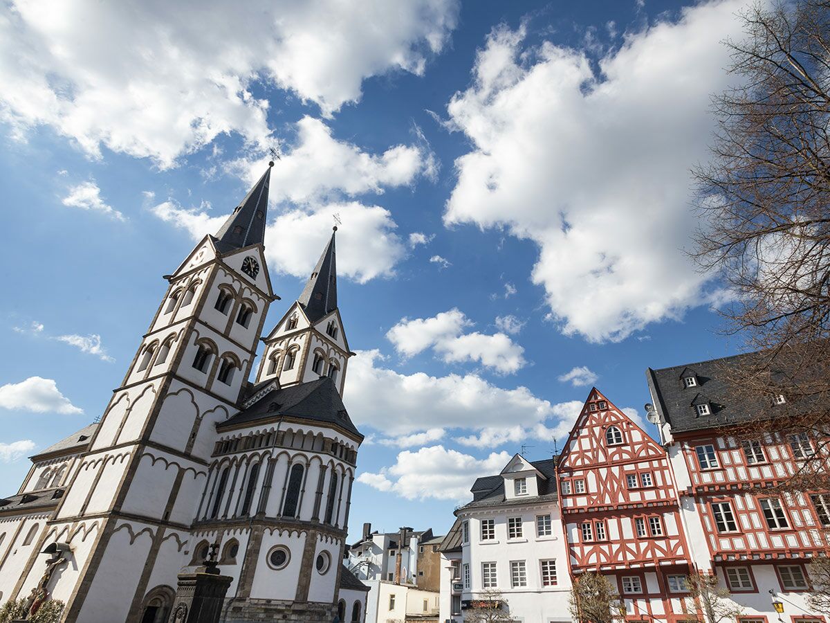 Historische Stadtansicht von Limburg mit dem Dom St. Georg und bunten Fachwerkhäusern unter strahlend blauem Himmel.