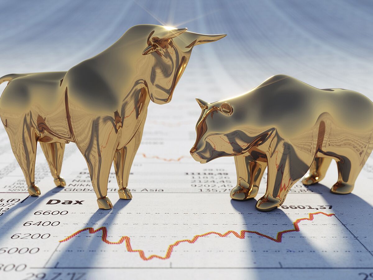 Goldene Bullen- und Bärenskulpturen symbolisieren Börsentrends auf einem Finanzchart mit Kursverlauf und Dax-Daten.