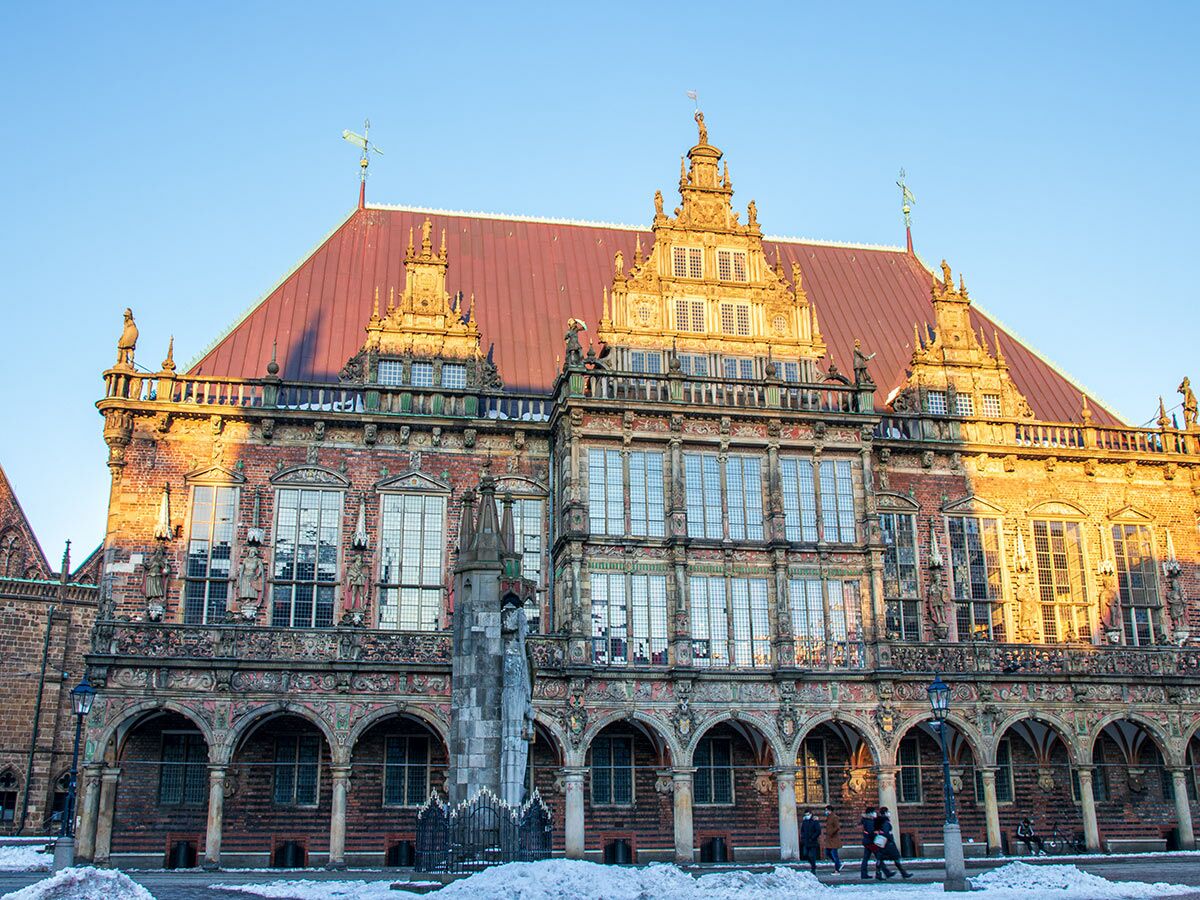 Historisches Bremer Rathaus im Winter mit Schnee und blauem Himmel bei Sonnenuntergang, Renaissance-Architektur.