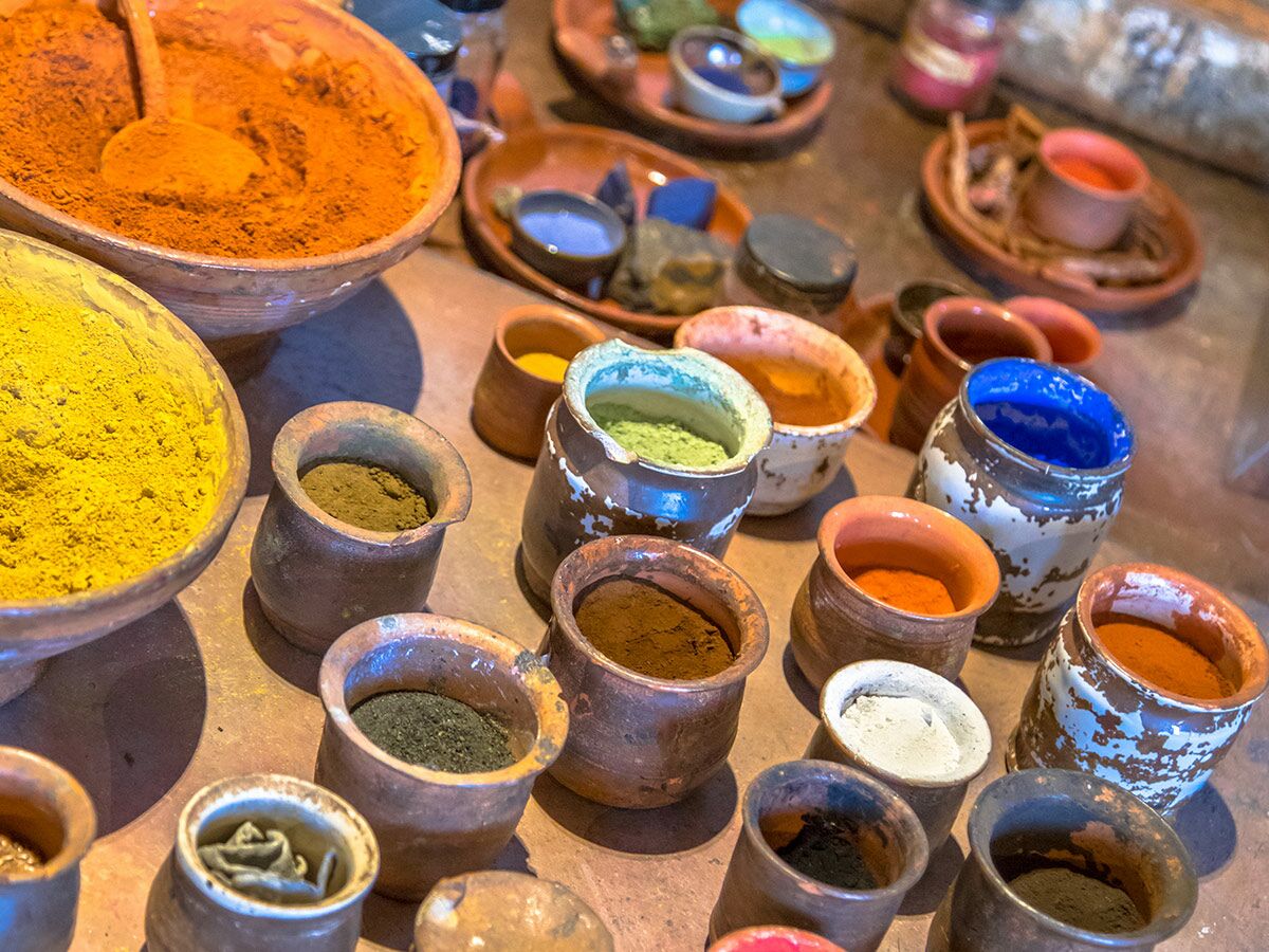 Verschiedene bunte Naturfarben und Pigmente in rustikalen Tongefäßen, bereit zur Verwendung für Kunst und Handwerk.