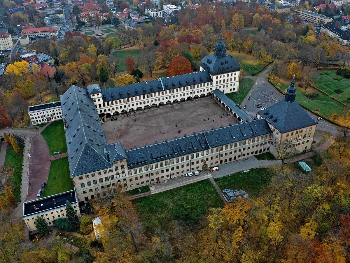 Luftbild von Schloss Friedenstein in Gotha im Herbst. Historischer Barockpalast mit bunten Bäumen und weitläufigem Park.