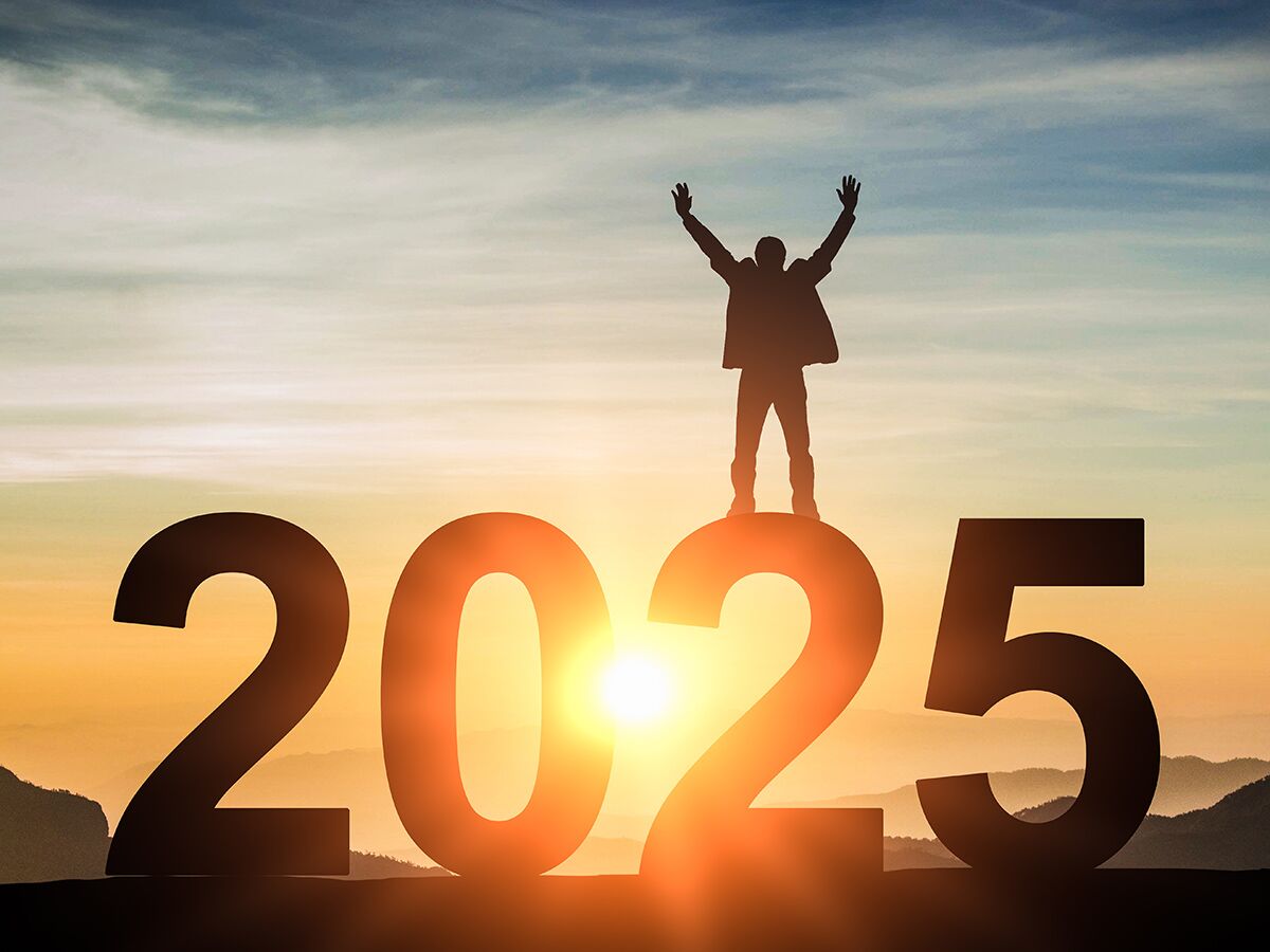 Silhouette eines Mannes feiert auf der Zahl 2025 bei Sonnenaufgang, symbolisiert Erfolg, Ziele und die Zukunft.