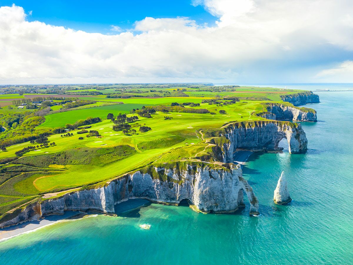 Luftbild Étretat: Kreidefelsen, Felsbögen, Aiguille, grüner Golfplatz auf Klippen in der Normandie am türkisen Meer.