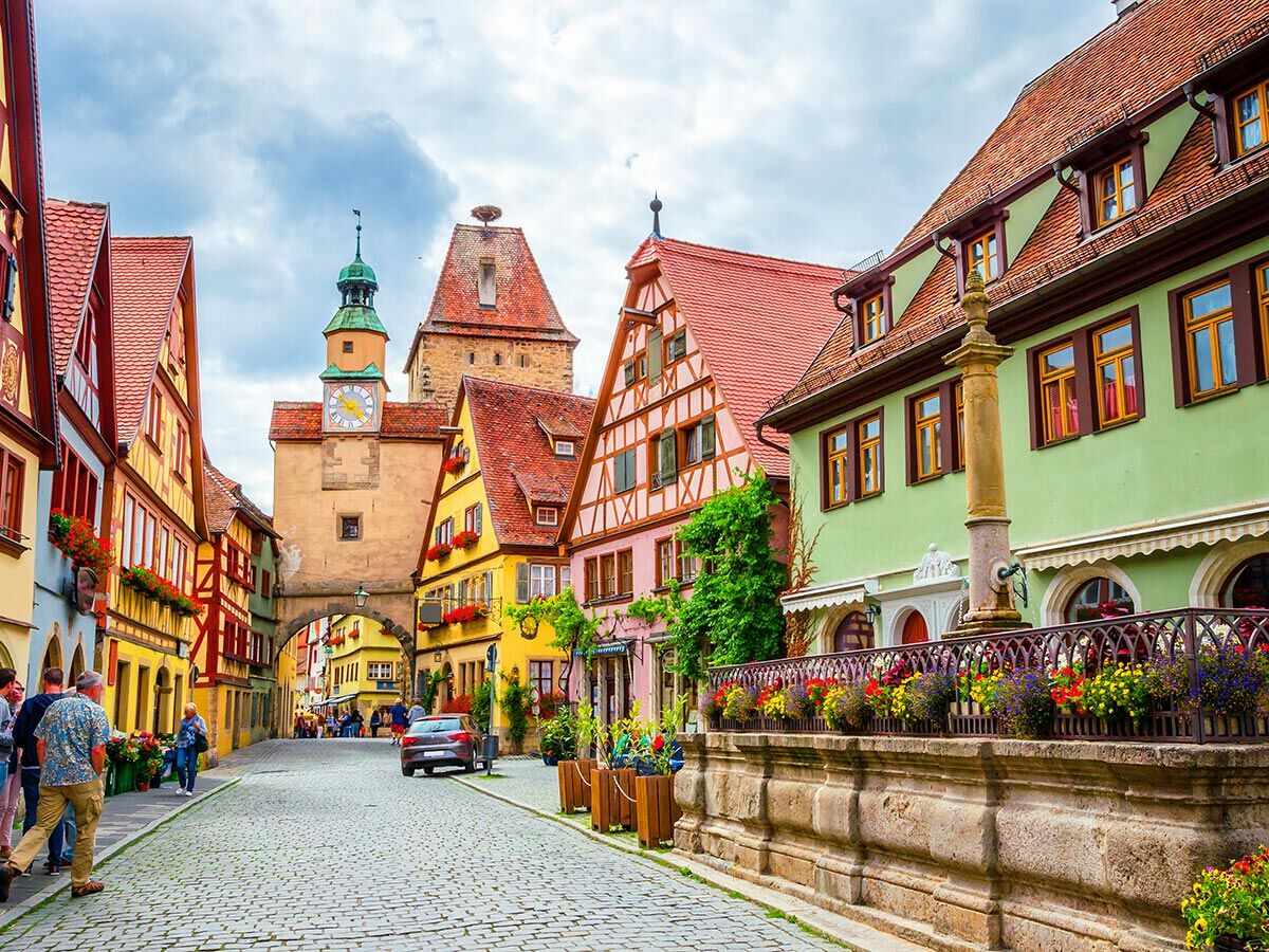 Malerische Gasse in Rothenburg ob der Tauber, Deutschland, mit farbigen Fachwerkhäusern, Kirchturm und Kopfsteinpflaster.