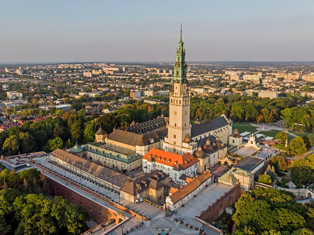 Luftaufnahme des Jasna Góra Klosters mit Turm, Basilika und Stadtpanorama in Częstochowa, Polen, bei Sonnenuntergang.