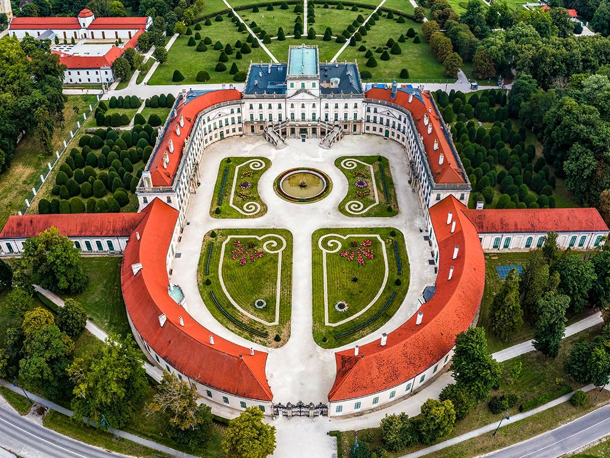 Luftaufnahme des Esterházy Schlosses in Fertőd, Ungarn, mit weitläufigen Barockgärten, Springbrunnen und symmetrischen Anlagen.