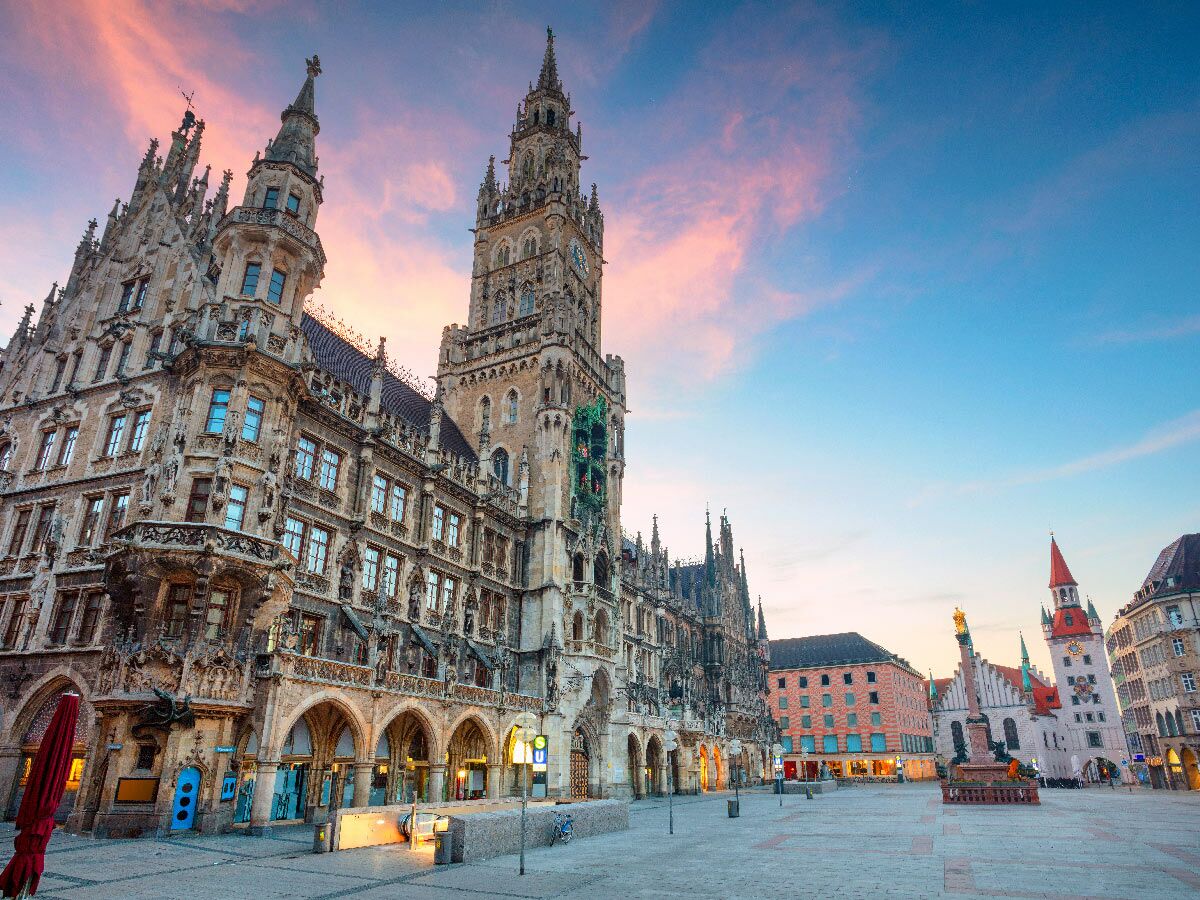 Neues Rathaus am Marienplatz in München bei Sonnenuntergang, mit gotischer Architektur, Uhrturm und farbigem Himmel.