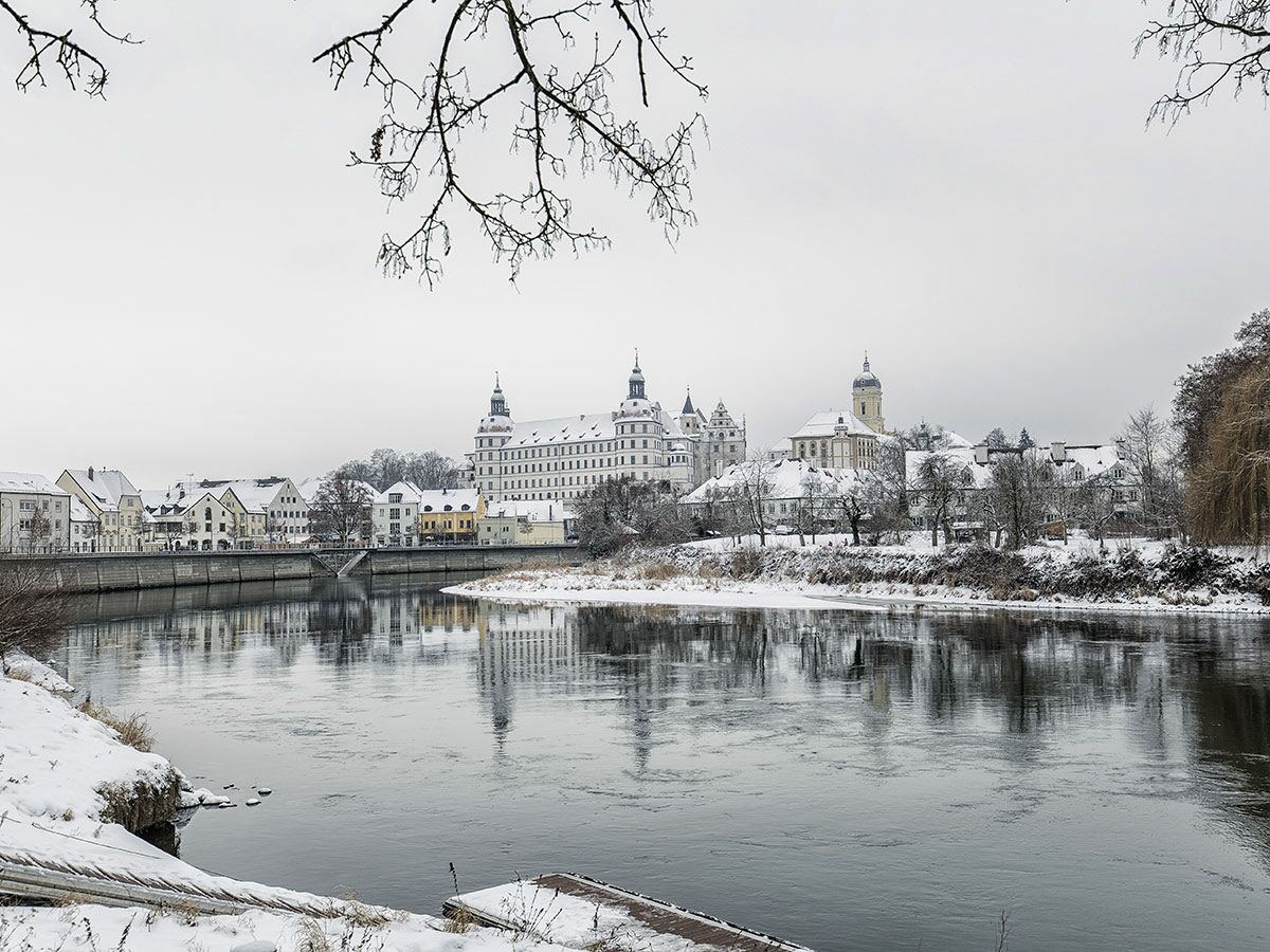 Historisches Kloster Banz in Bayern, Deutschland, bedeckt mit Schnee im Winter, spiegelt sich im Fluss Main wider.