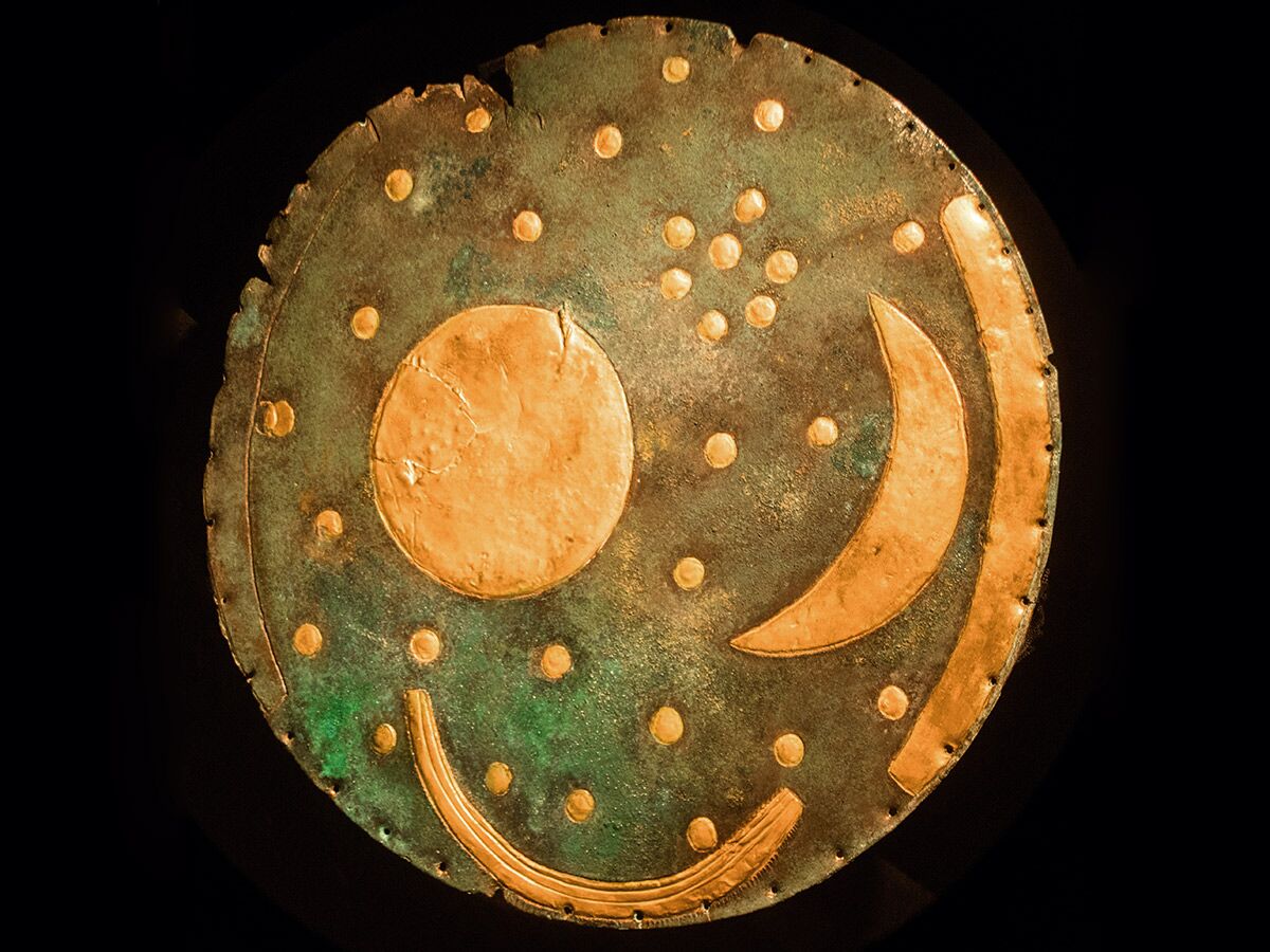 Die Nebraer Himmelsscheibe, eine runde Bronzezeit-Scheibe mit Sonne, Mond, Sternen und goldenen Inlays auf grüner Patina.