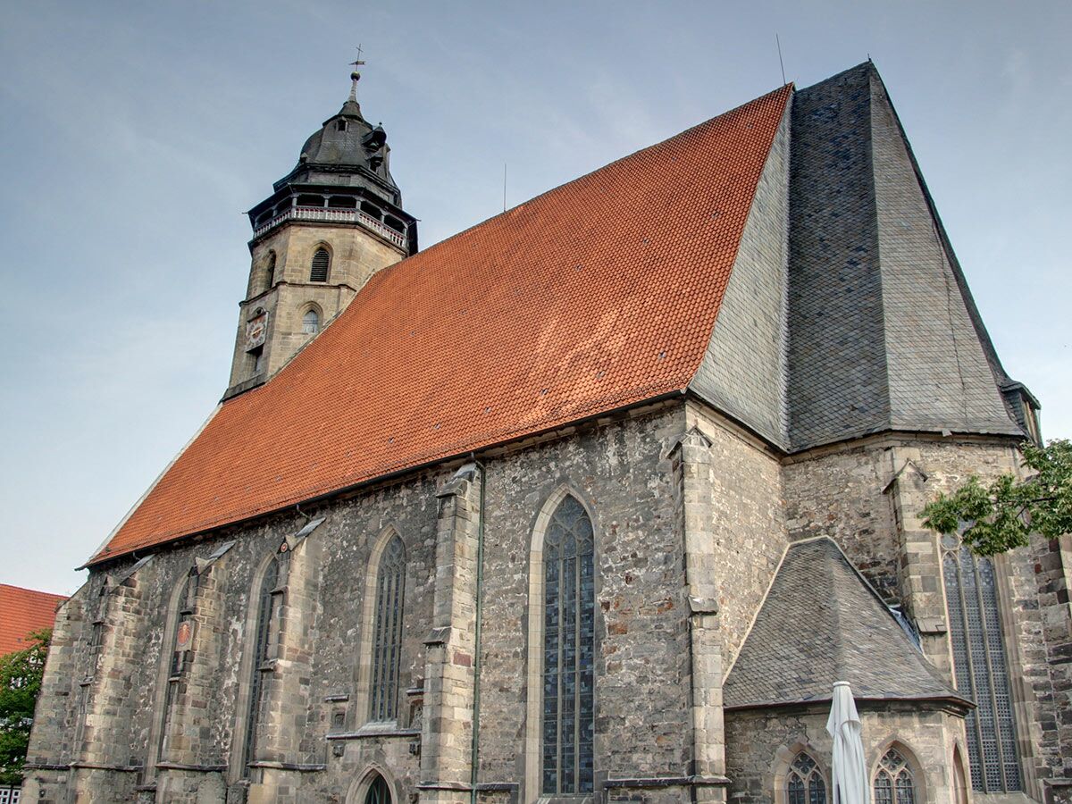 Historische St. Jacobi Kirche in Göttingen mit markantem roten Ziegeldach, hohem Steinturm und gotischen Fenstern.