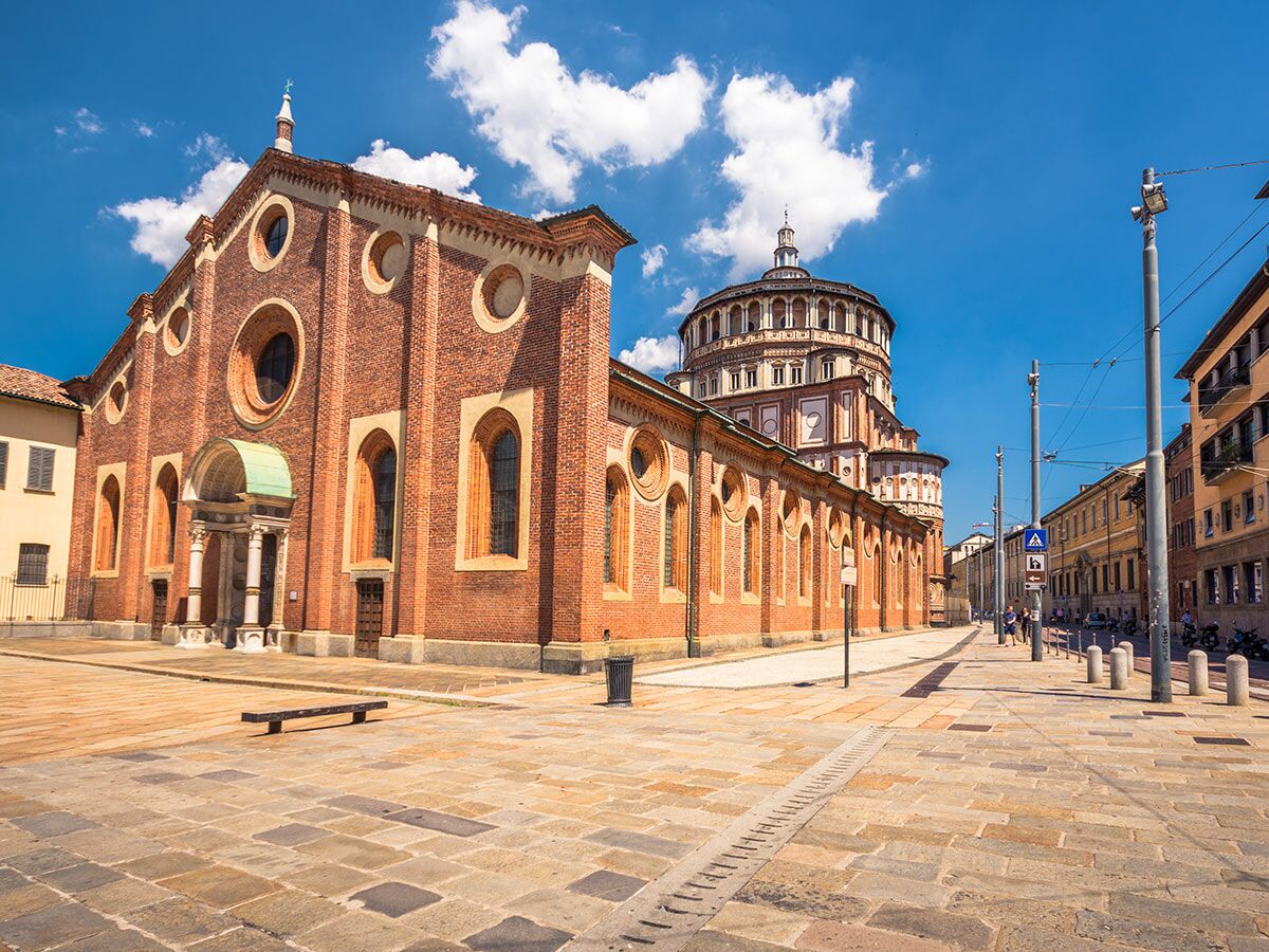 Historische Santa Maria delle Grazie Kirche in Mailand, Italien, unter blauem Himmel mit Wolken und Straße.