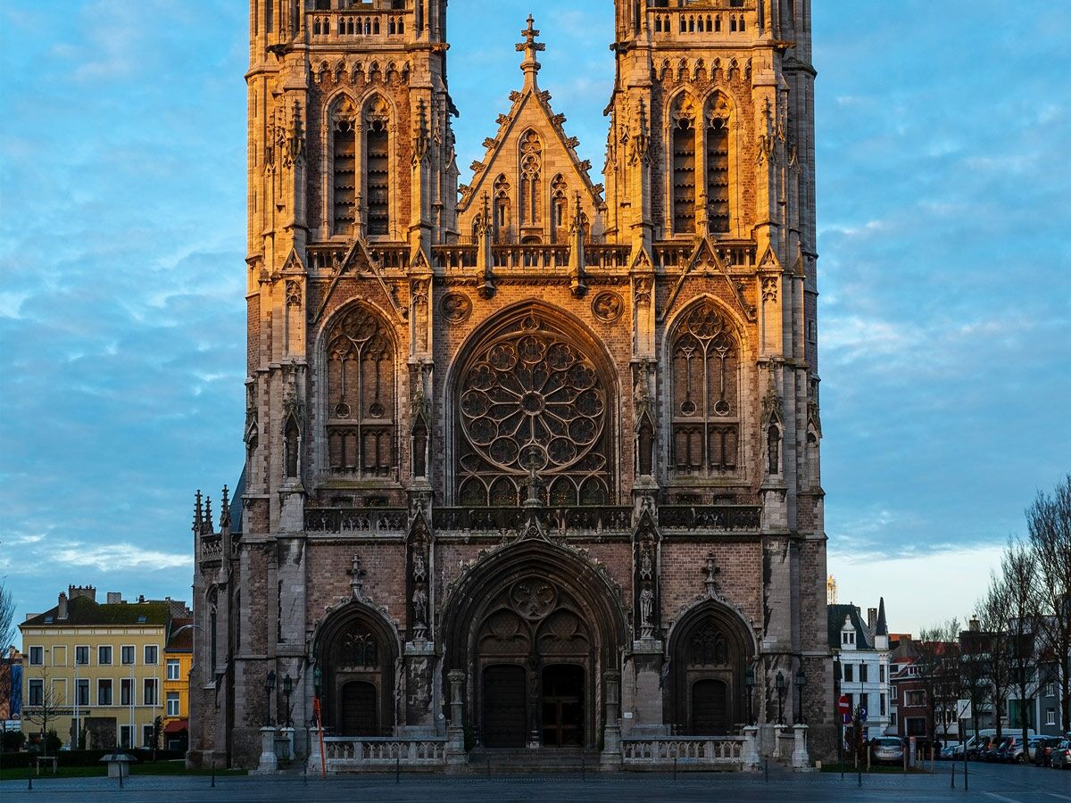 Majestätische gotische Kathedrale von Arras im goldenen Morgenlicht mit zwei Türmen, Rosettenfenster und reich verzierten Details.