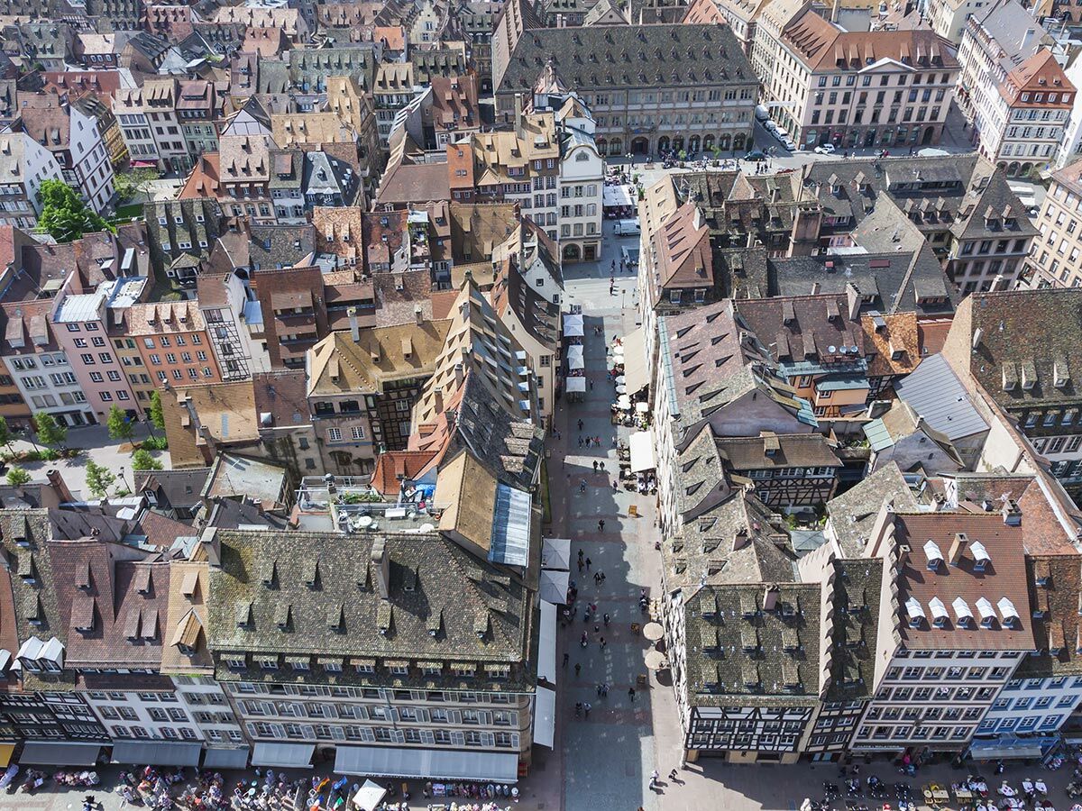 Luftbild von Straßburgs historischer Altstadt mit engen Gassen, roten Ziegeldächern, Fachwerkhäusern und belebten Straßen.