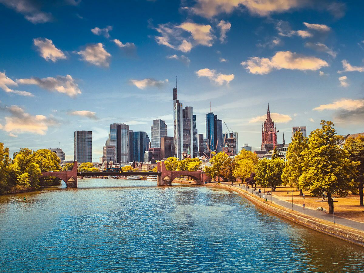 Panoramablick auf die Frankfurter Skyline mit Hochhäusern, Main und Brücken an einem sonnigen Herbsttag.