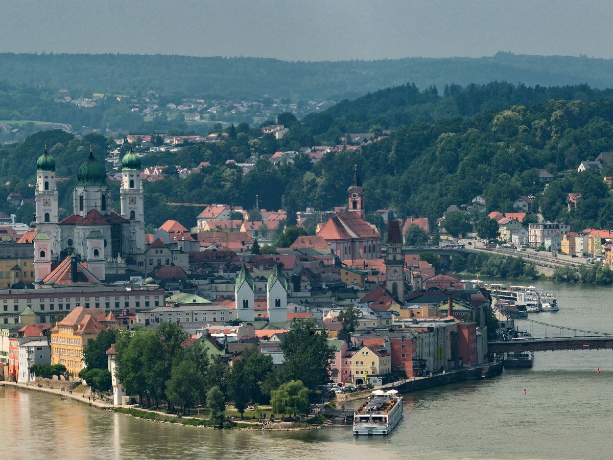 Panoramablick auf Passau, die Dreiflüssestadt. Historische Gebäude, Dom St. Stephan, bunte Häuser, Flüsse und Schiffe.