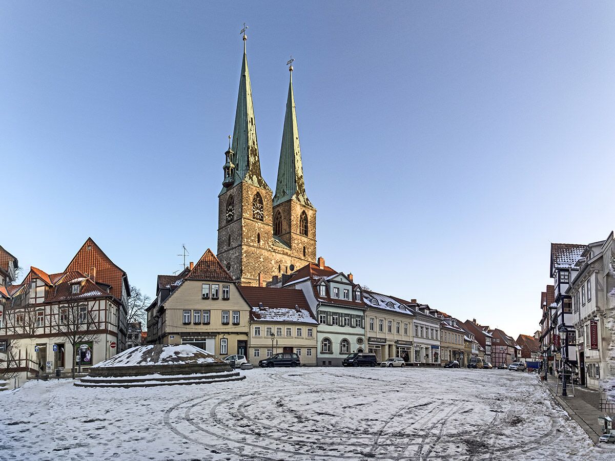 Winterliche Ansicht des Hildesheimer Altstadtmarktes mit schneebedecktem Platz, historischen Häusern und der St. Godehard Kirche.